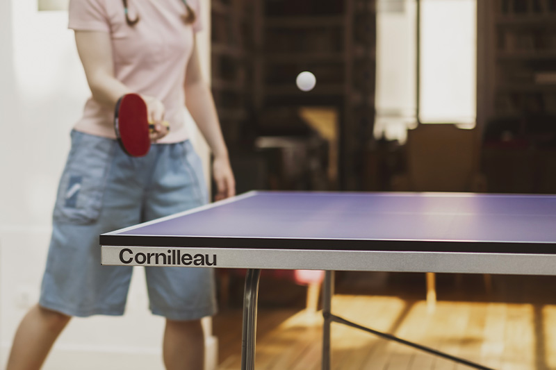 joueuse qui joue sur la table de ping pong Cornilleau 100 indoor